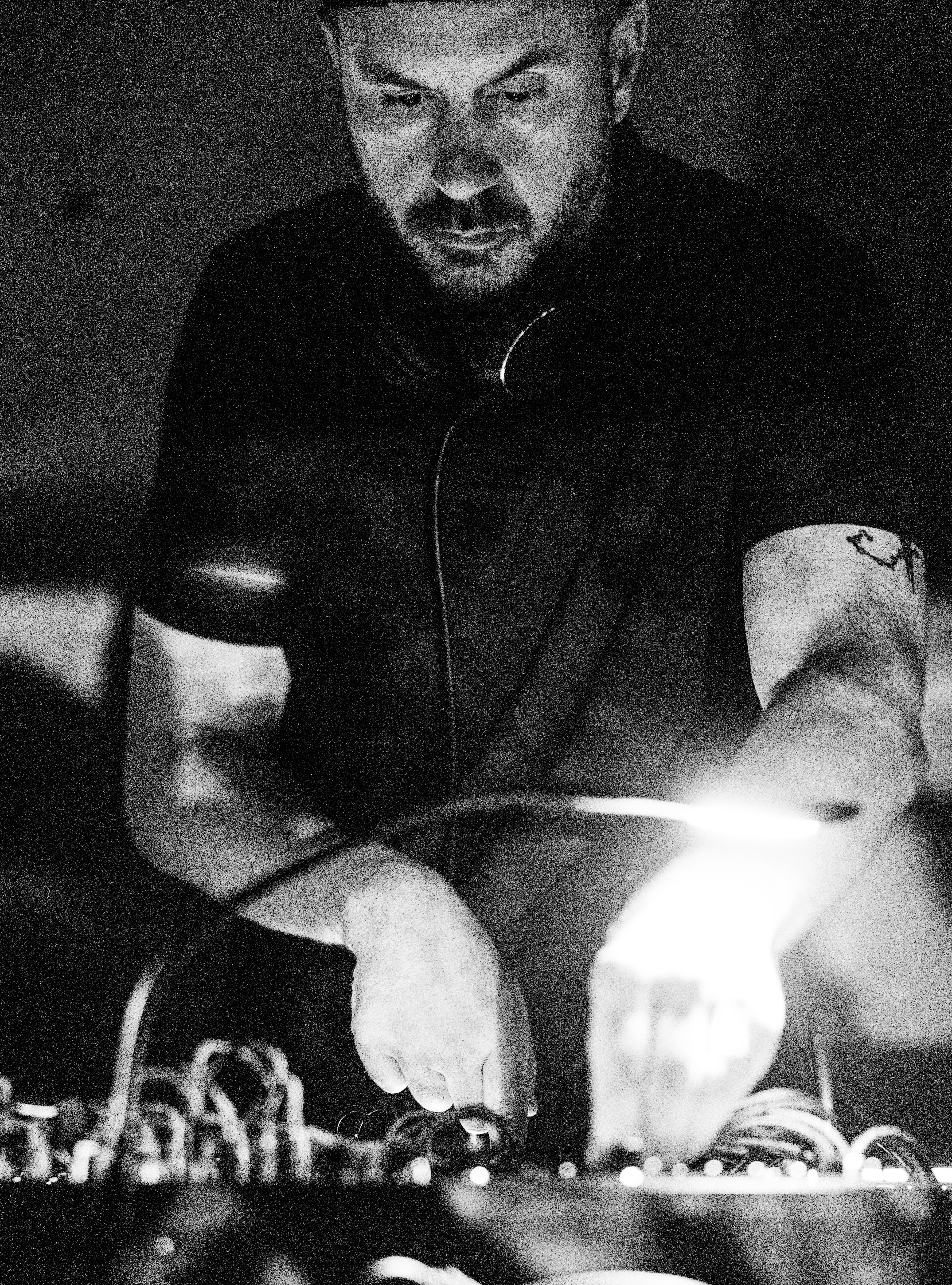 William White performing on hardware synthesizers — monochrome close-up